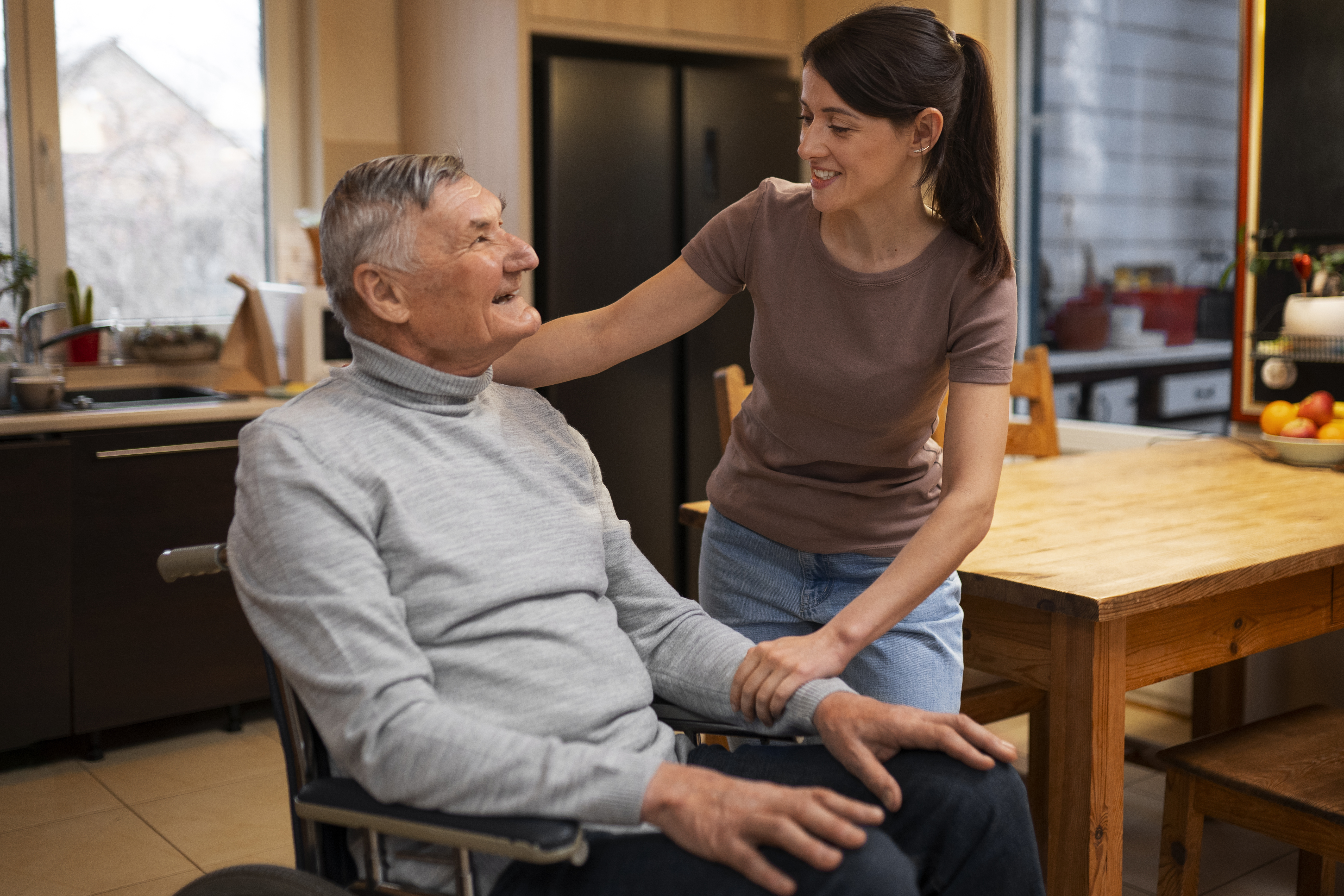 Caregiver sitting with an older adult at a residential care home